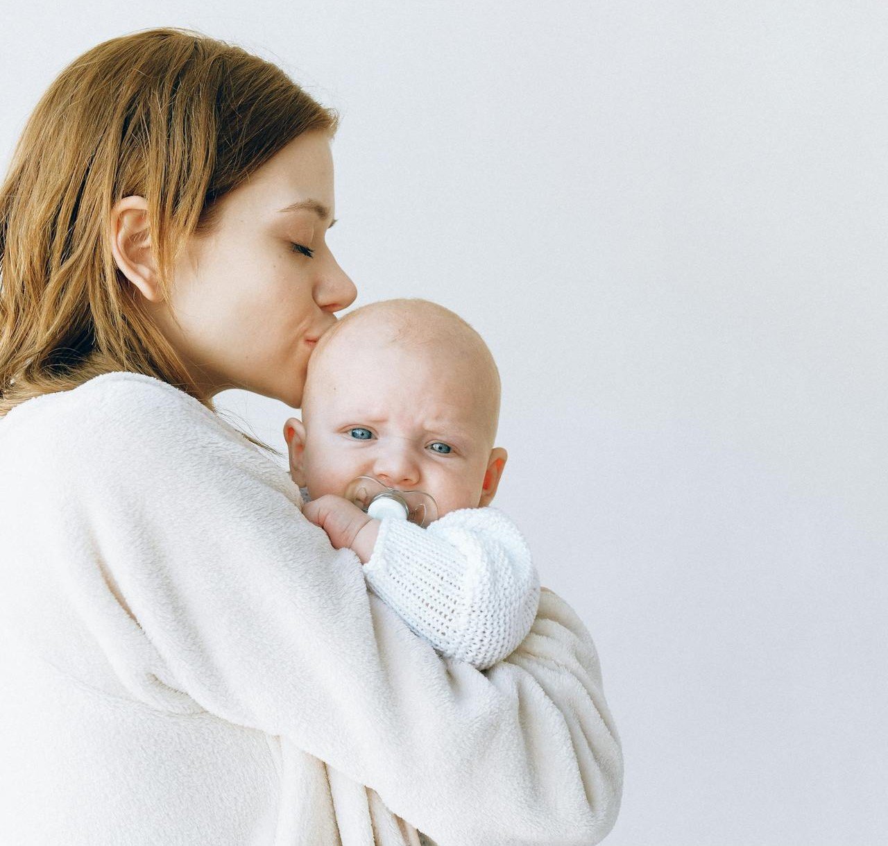 Bebis som gråter i sin mammas famn